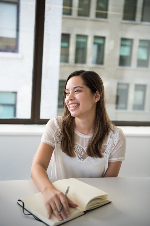 woman-wearing-white-t-shirt-holding-notebook-and-pen